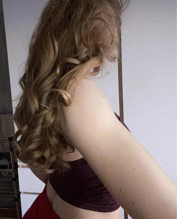 Light brown hair falling in bouncy curls over a shoulder after the Classic Curling Rod