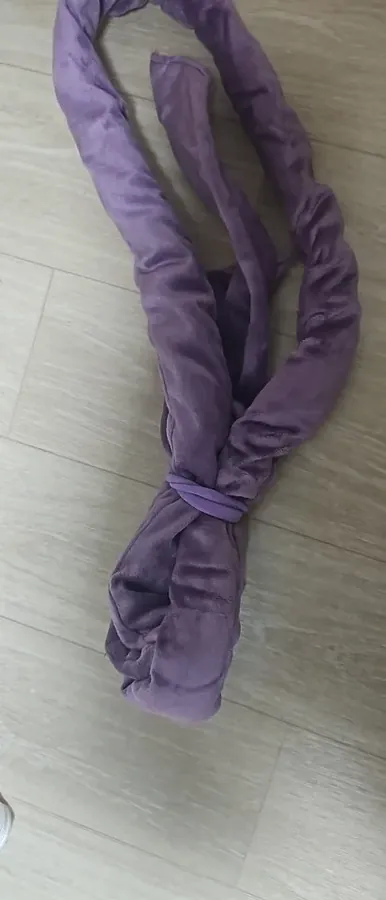 Lilac Classic Curling Rod tied in a loop on a tiled floor