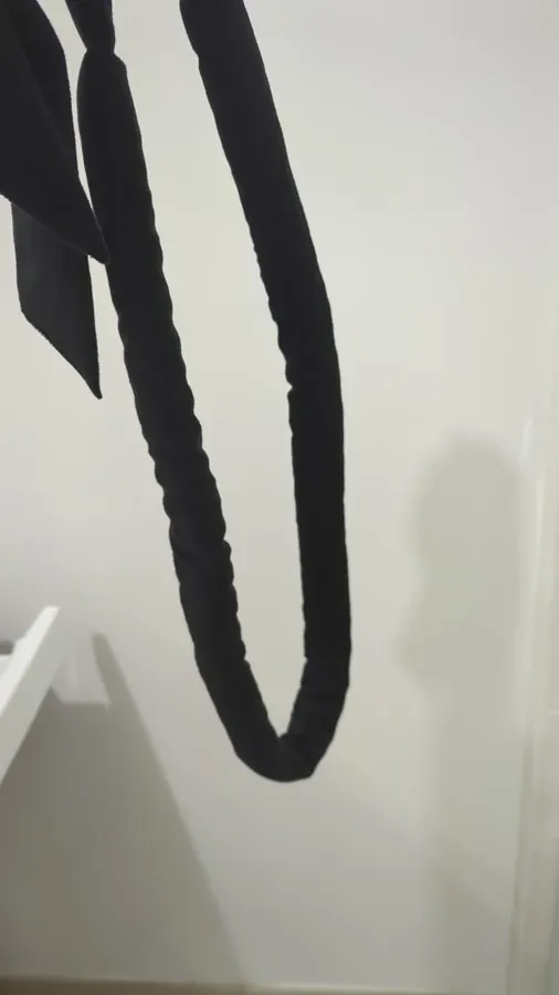 Black Classic Curling Rod hanging from its flat ribbon ends